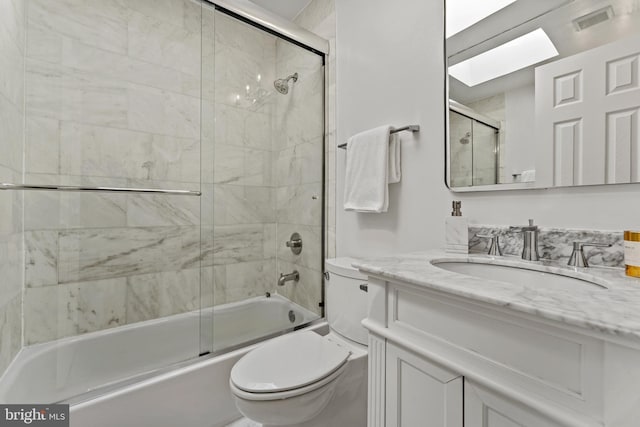 full bath with visible vents, toilet, a skylight, enclosed tub / shower combo, and vanity