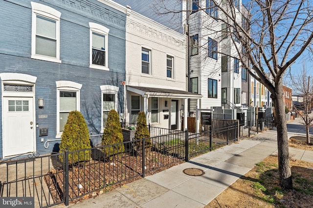 townhome / multi-family property with a fenced front yard and a residential view