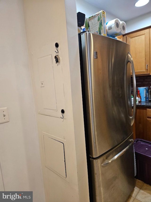 kitchen featuring dark countertops, freestanding refrigerator, and electric panel