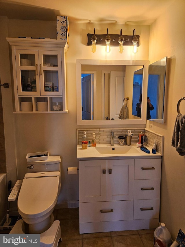 bathroom featuring decorative backsplash, toilet, vanity, and tile patterned flooring