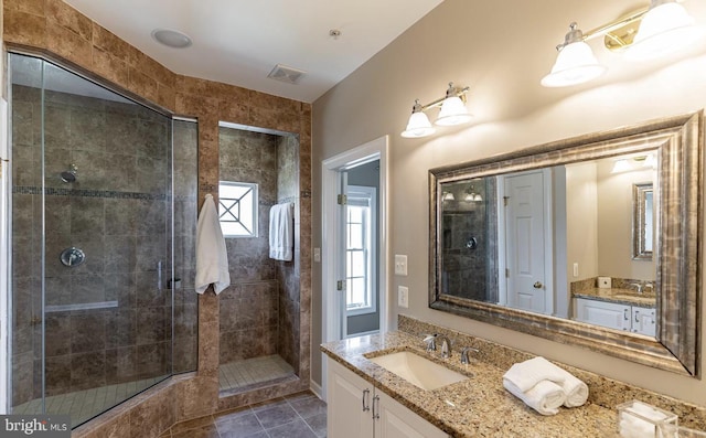 bathroom featuring tile patterned floors, visible vents, vanity, and a shower stall