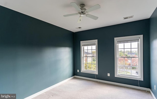 carpeted empty room featuring visible vents, baseboards, and a ceiling fan