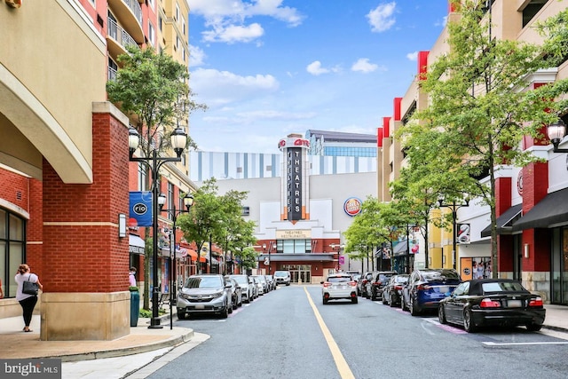 view of street with a view of city, curbs, street lights, and sidewalks