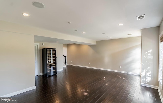 unfurnished room featuring recessed lighting, visible vents, baseboards, and dark wood-type flooring