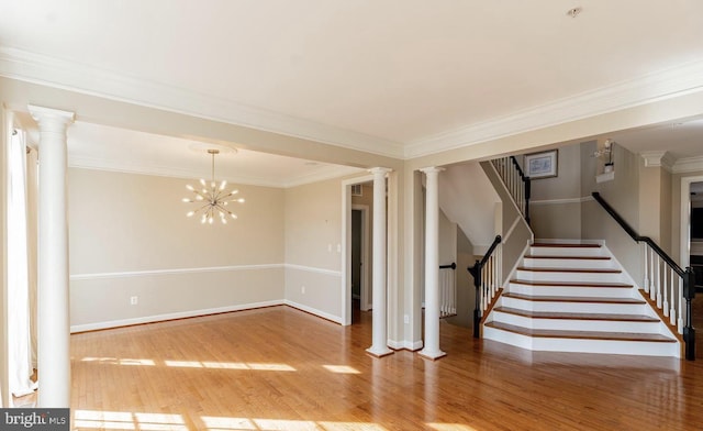 interior space with wood finished floors, stairway, crown molding, decorative columns, and baseboards