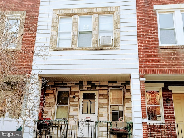 view of front of home with a porch and brick siding