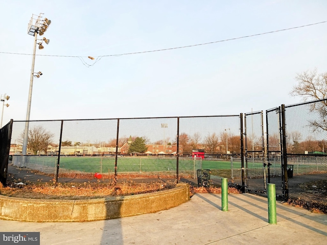 surrounding community with a gate, a tennis court, and fence