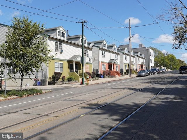 view of road with a residential view, curbs, and sidewalks