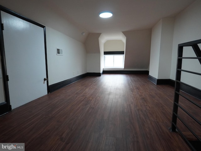 bonus room featuring baseboards, dark wood-style flooring, and vaulted ceiling