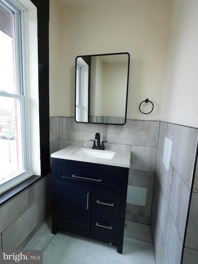 bathroom with vanity, tile walls, and wainscoting