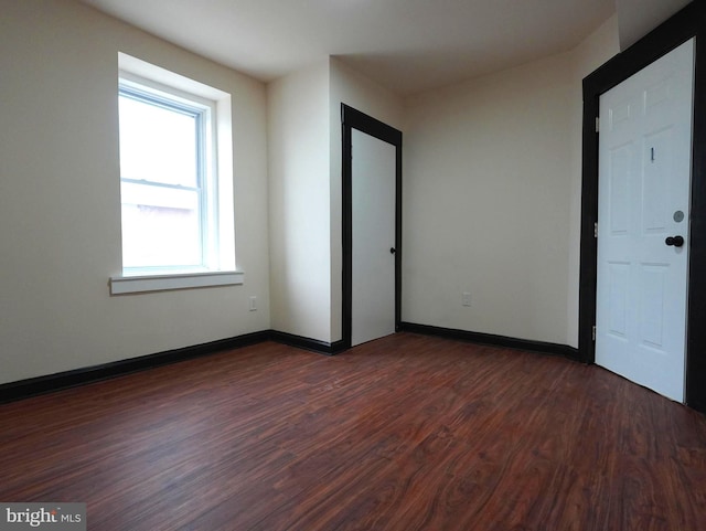 unfurnished room featuring dark wood finished floors and baseboards