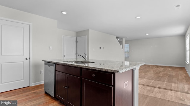 kitchen featuring light stone countertops, visible vents, a sink, stainless steel dishwasher, and light wood-type flooring