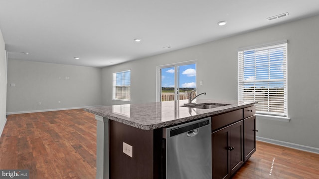 kitchen with visible vents, a kitchen island with sink, a sink, stainless steel dishwasher, and open floor plan