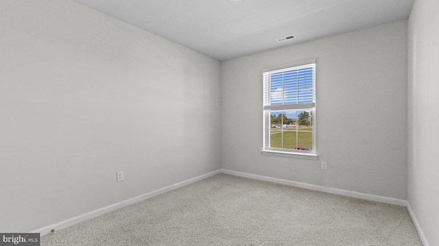 carpeted spare room with baseboards and visible vents