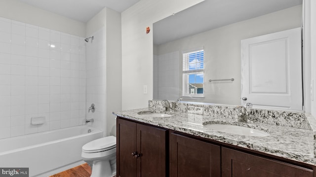 full bathroom featuring wood finished floors, toilet, shower / tub combination, and a sink