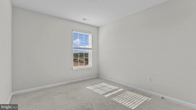 carpeted empty room featuring baseboards and visible vents