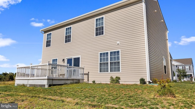 rear view of property with a deck and a yard