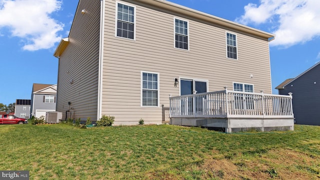 rear view of house featuring central air condition unit, a lawn, and a wooden deck