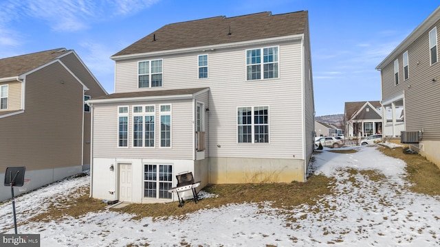 snow covered back of property with central AC unit