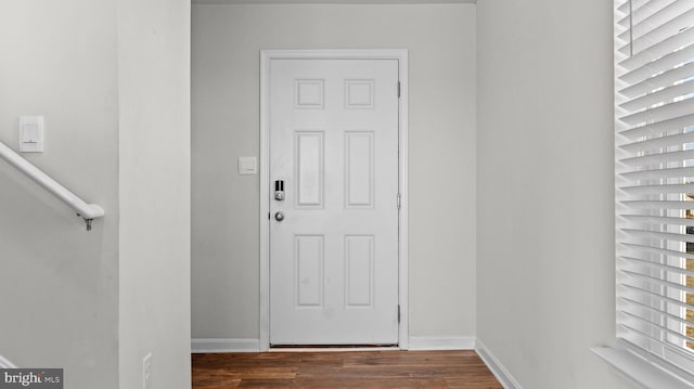 doorway featuring dark wood-style floors and baseboards