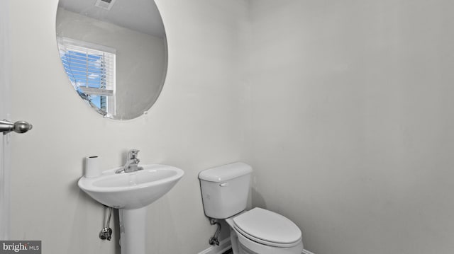 bathroom featuring toilet and baseboards