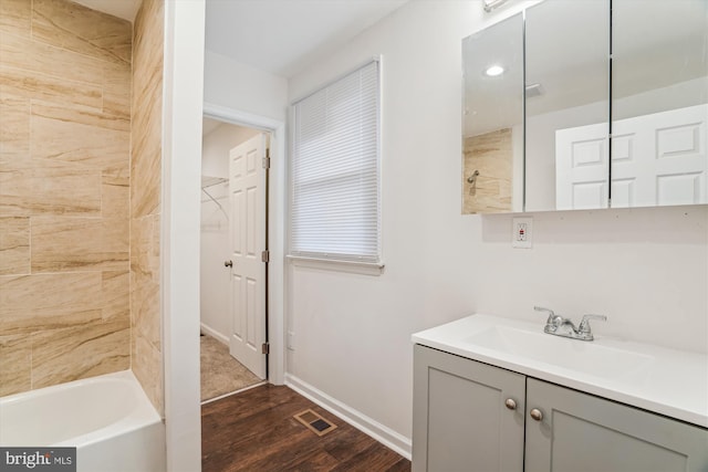 bathroom with vanity, wood finished floors, visible vents, a tub to relax in, and a shower