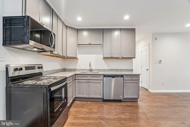 kitchen with gray cabinets, appliances with stainless steel finishes, and a sink