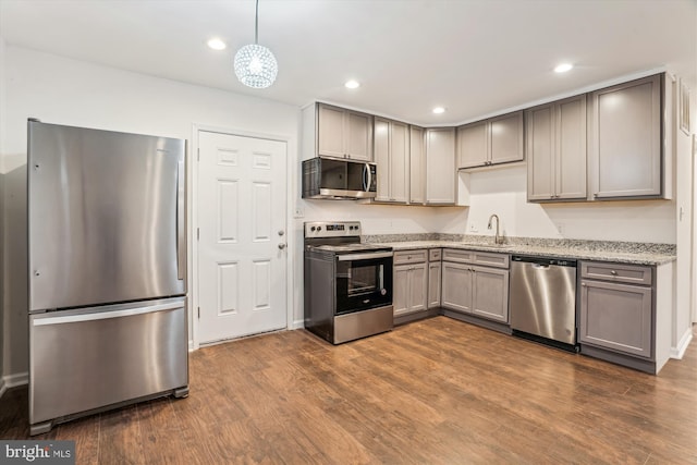 kitchen with a sink, gray cabinetry, dark wood-style flooring, and stainless steel appliances