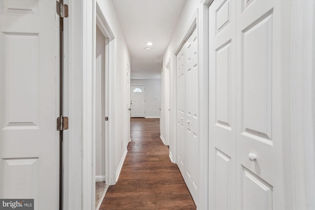 hall with dark wood-type flooring and baseboards