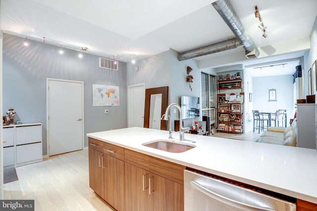 kitchen with visible vents, track lighting, a sink, light countertops, and dishwasher