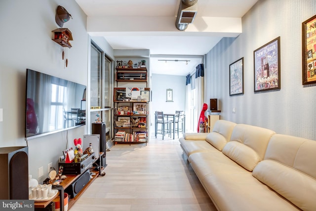 living area featuring track lighting, light wood-style flooring, wallpapered walls, and visible vents