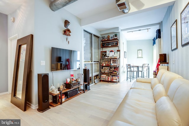 living room with track lighting, baseboards, and wood finished floors