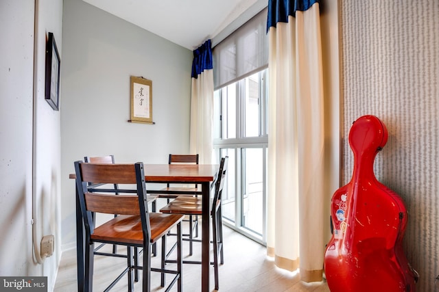 dining area featuring a healthy amount of sunlight, light floors, and baseboards