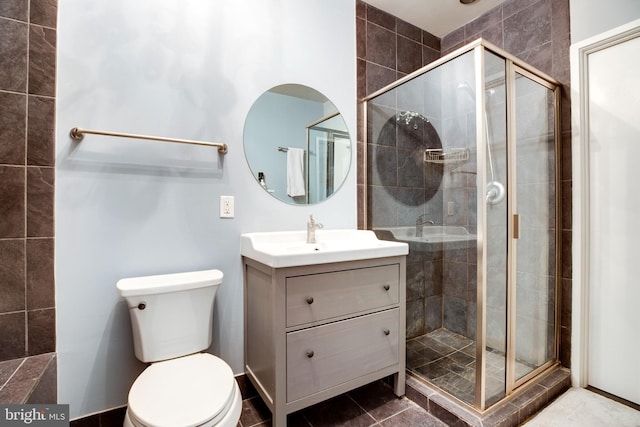 full bath with tile patterned flooring, a shower stall, vanity, and toilet