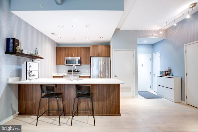 kitchen with light countertops, modern cabinets, brown cabinets, and stainless steel appliances