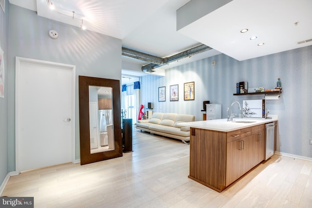 interior space featuring visible vents, wallpapered walls, dishwasher, light wood-type flooring, and a sink