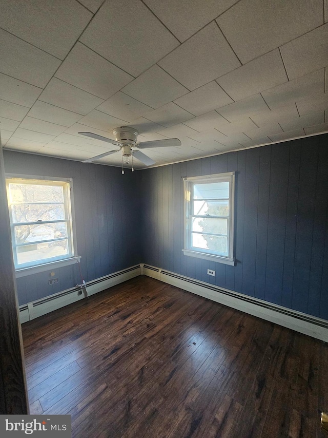 empty room with a ceiling fan, wood finished floors, and a healthy amount of sunlight