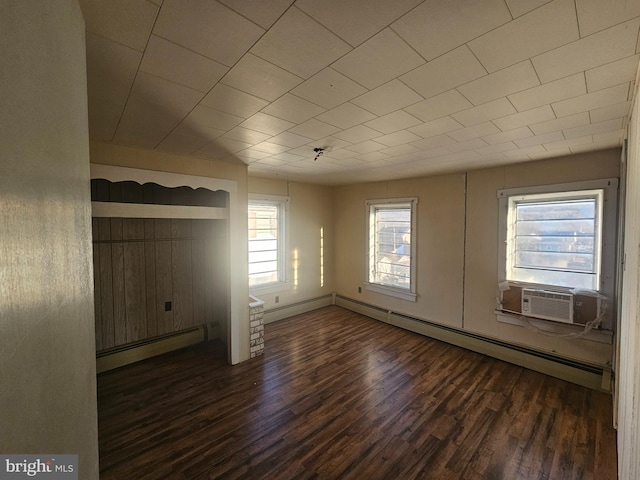 unfurnished living room featuring a wealth of natural light, a baseboard radiator, and dark wood finished floors