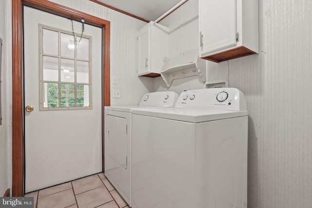 washroom featuring light tile patterned floors, cabinet space, and washer and clothes dryer