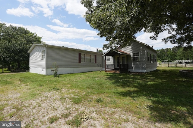 back of house with crawl space, a yard, and fence