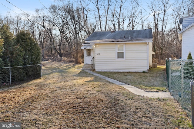 back of house featuring a yard and fence