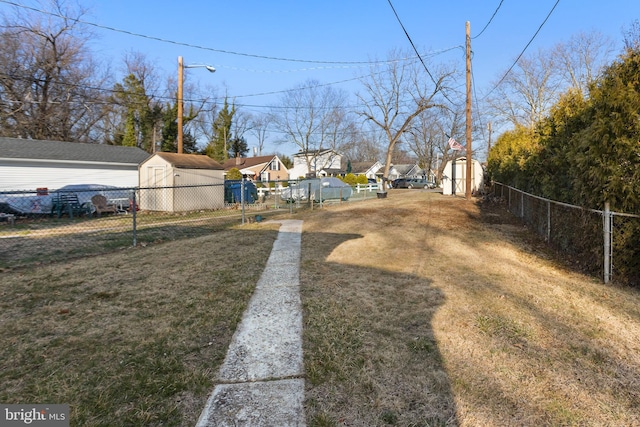 view of yard featuring a storage unit, an outdoor structure, and fence private yard