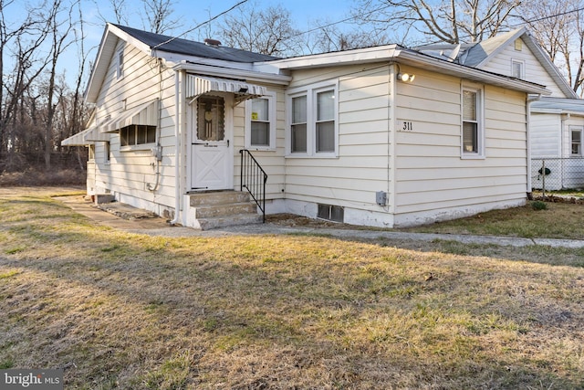 view of front of house featuring entry steps and a front lawn