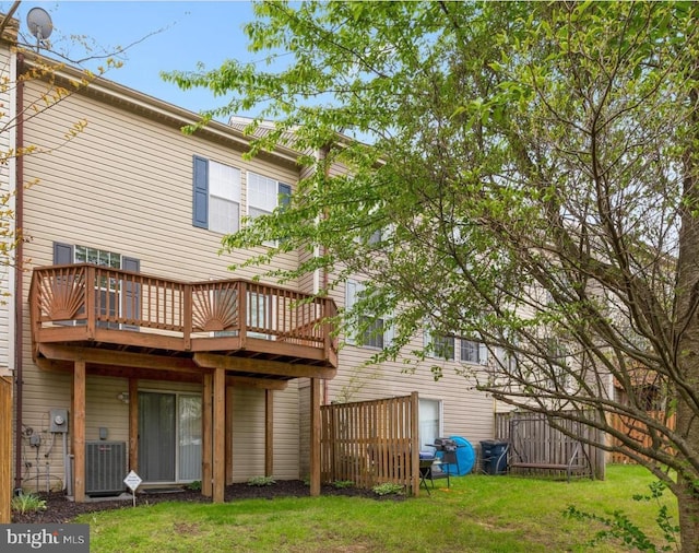 back of property with a yard, central AC, and a wooden deck