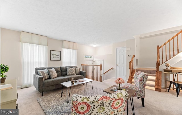 living area with light colored carpet and a textured ceiling