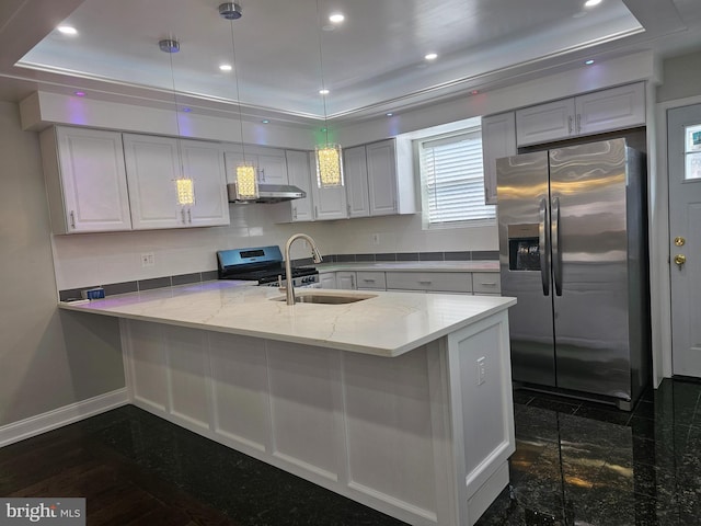 kitchen featuring recessed lighting, a peninsula, granite finish floor, stainless steel appliances, and a sink