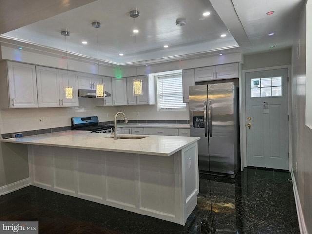 kitchen with recessed lighting, appliances with stainless steel finishes, a peninsula, granite finish floor, and a sink