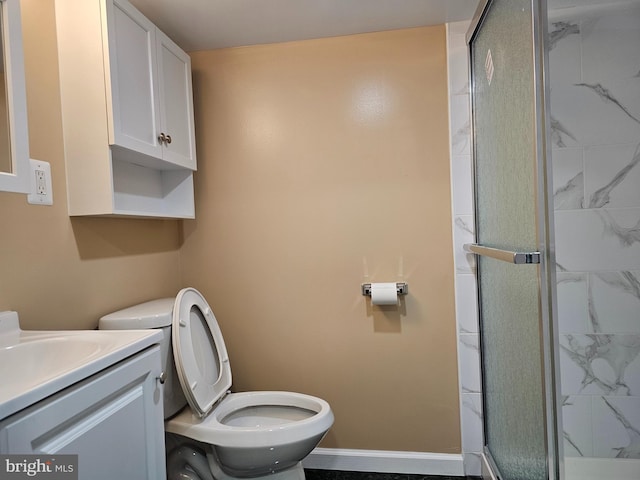 full bathroom featuring baseboards, toilet, vanity, and a shower stall