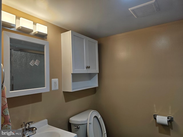 bathroom featuring a sink, visible vents, and toilet