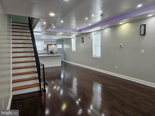 unfurnished living room with visible vents, dark wood-type flooring, baseboards, stairs, and recessed lighting